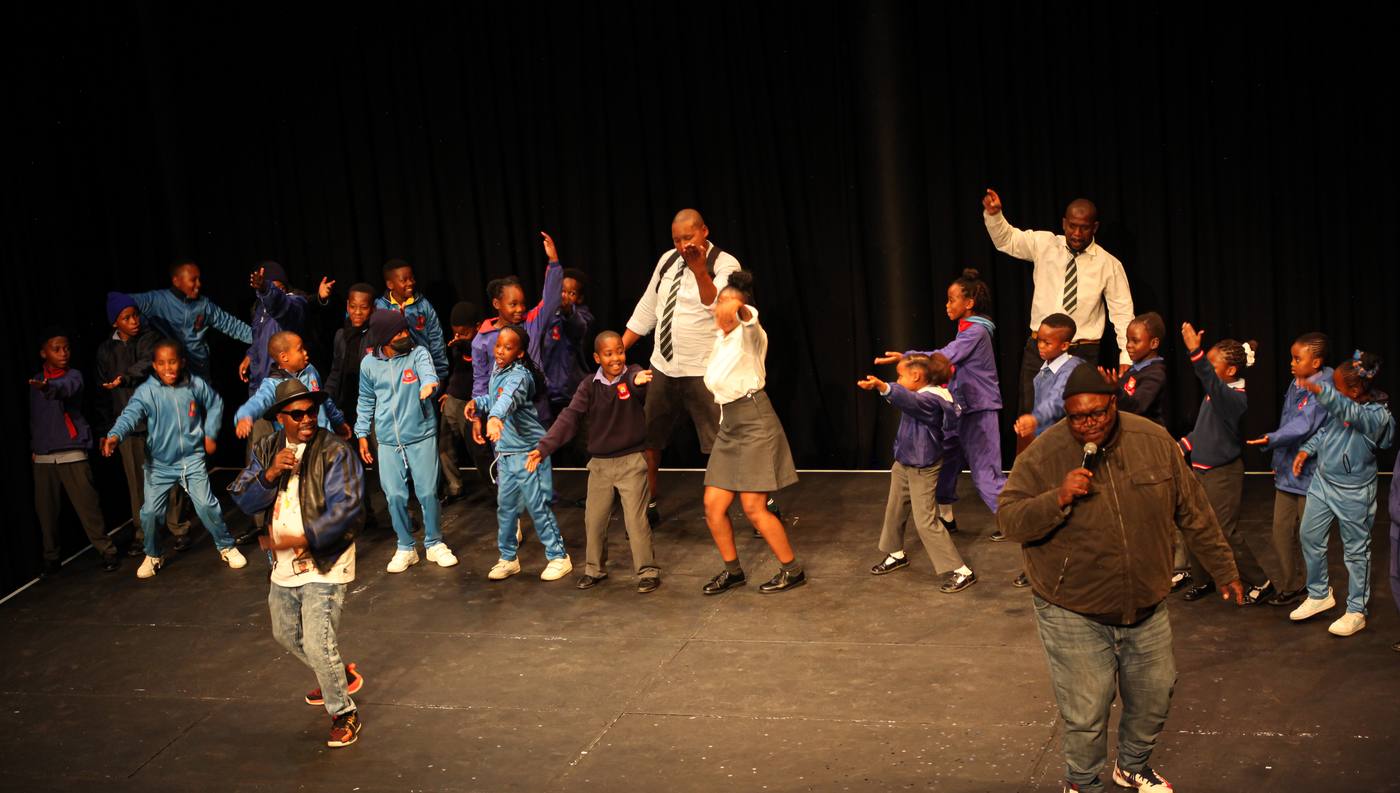 Learners dancing on stage with the cast